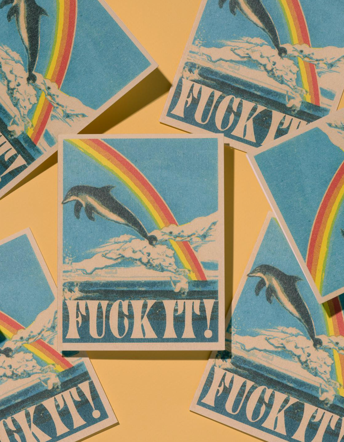 Stickers with dolphins, rainbows, and 'FUCK IT!' text on a yellow background