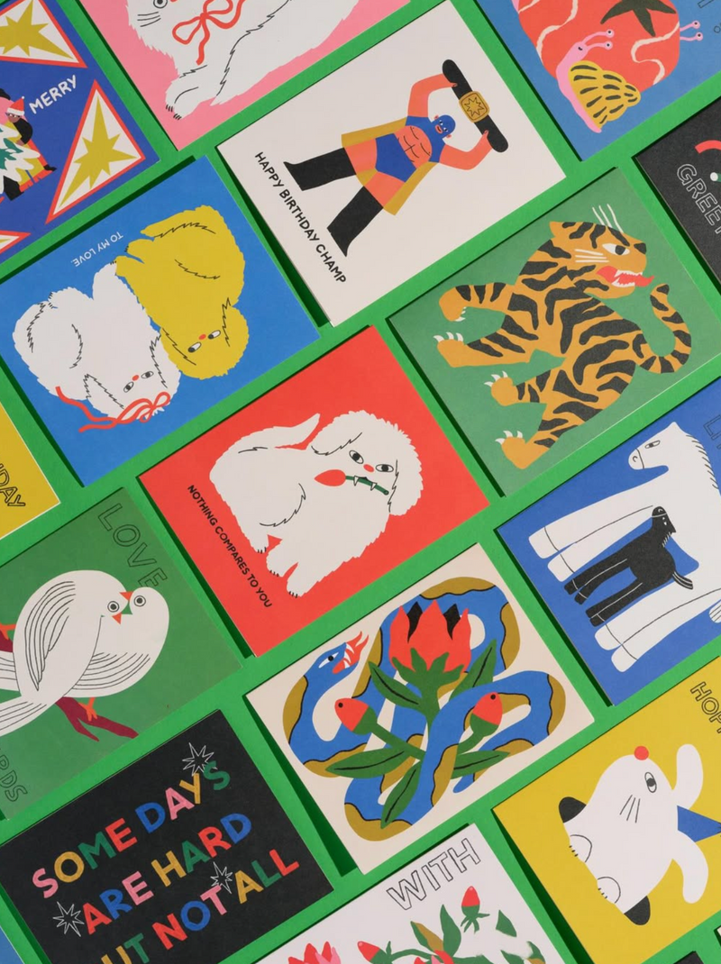 Collection of colorful greeting cards with various illustrations on a green background