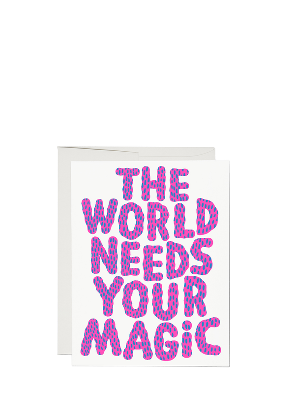 Greeting card with the text 'THE WORLD NEEDS YOUR MAGIC' in bold purple letters on a white background, accompanied by a matching envelope.