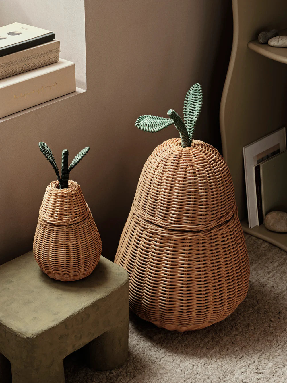 Wicker pear-shaped baskets with green leaf accents on a neutral background