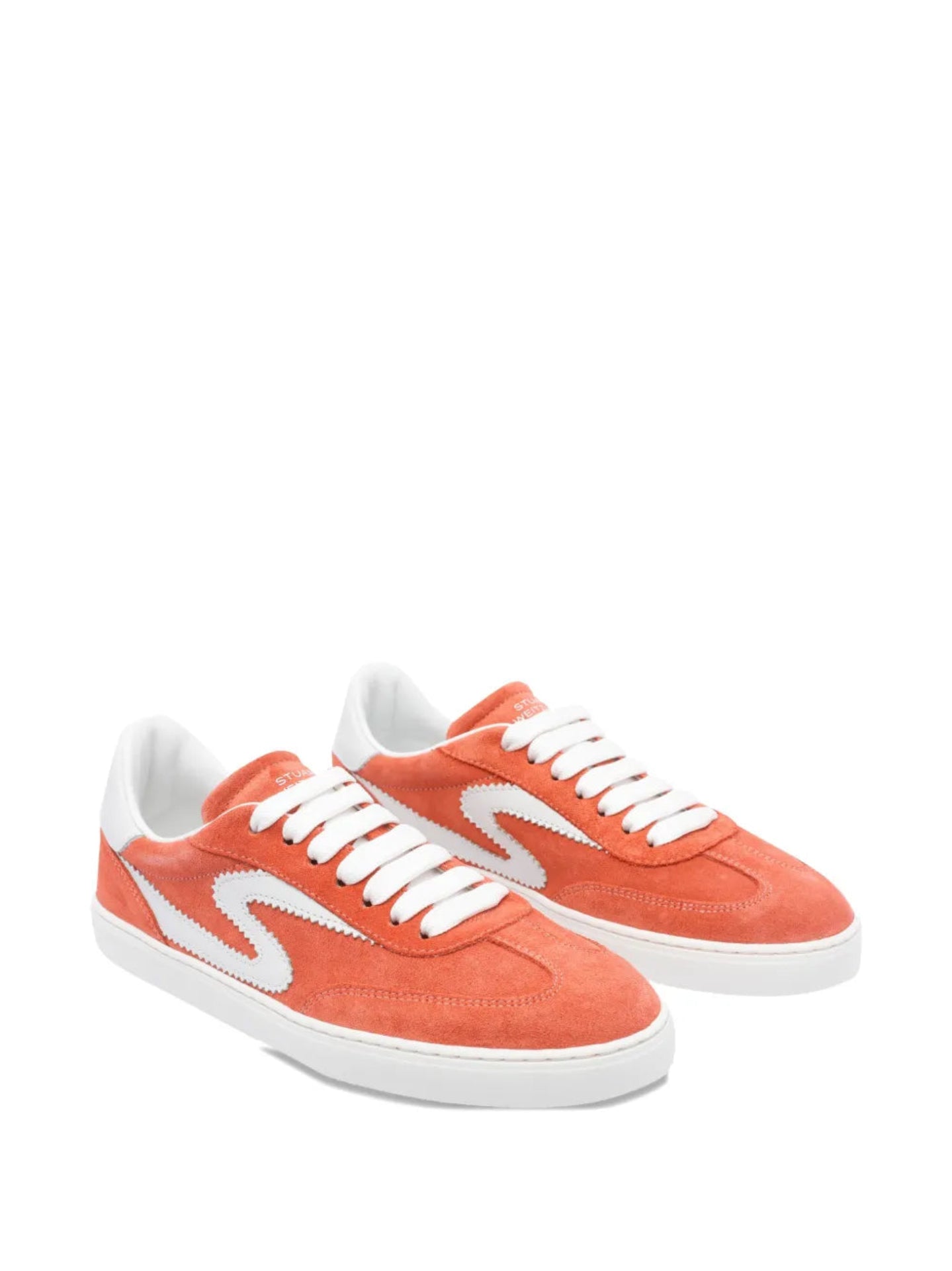Pair of orange sneakers with white laces on a white background