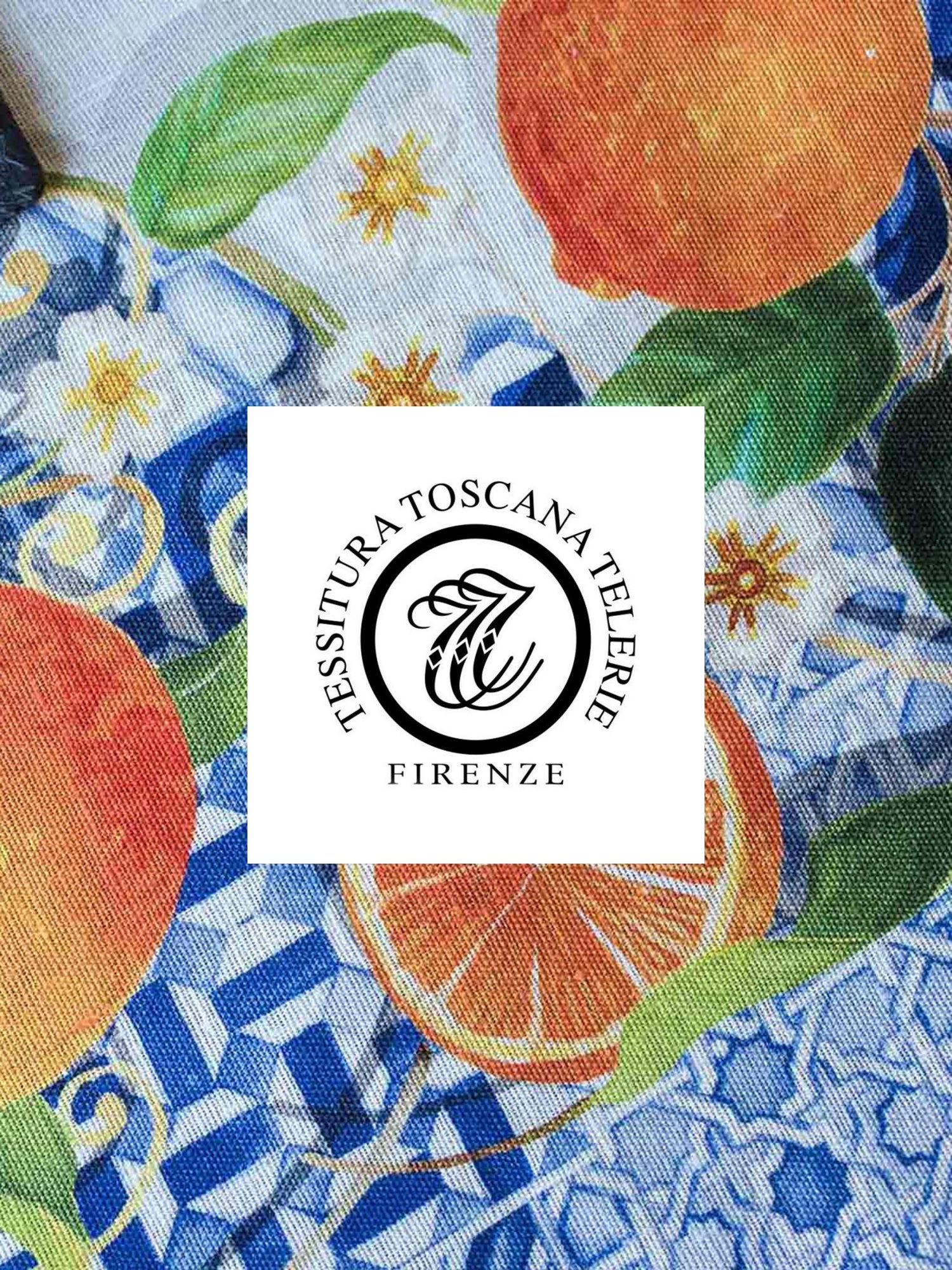 Fabric with colorful pattern featuring oranges and leaves, branded 'Tessitura Toscana Telerie Firenze'.