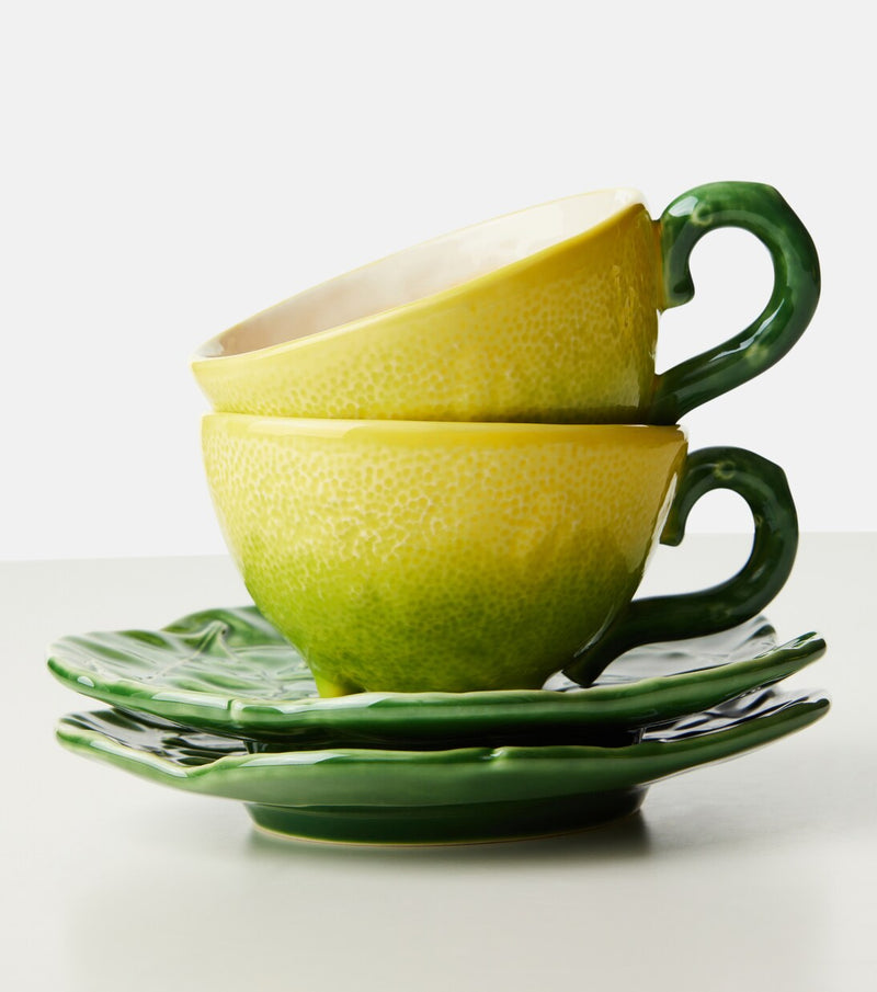Green ceramic teacup and saucer set on a white background