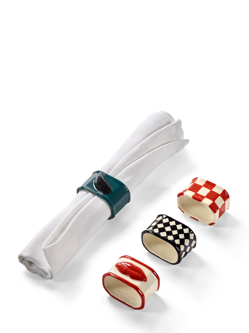 Four colorful napkin rings on a white background, one holding a white napkin.