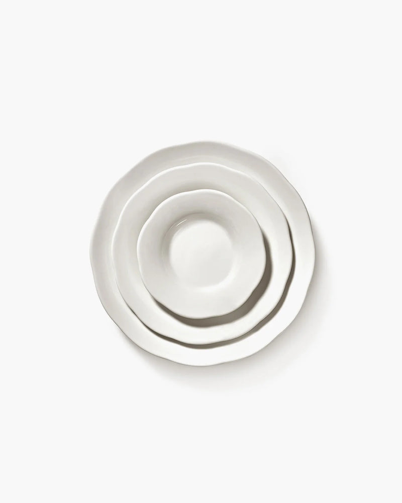 Set of three white ceramic bowls of different sizes on a white background