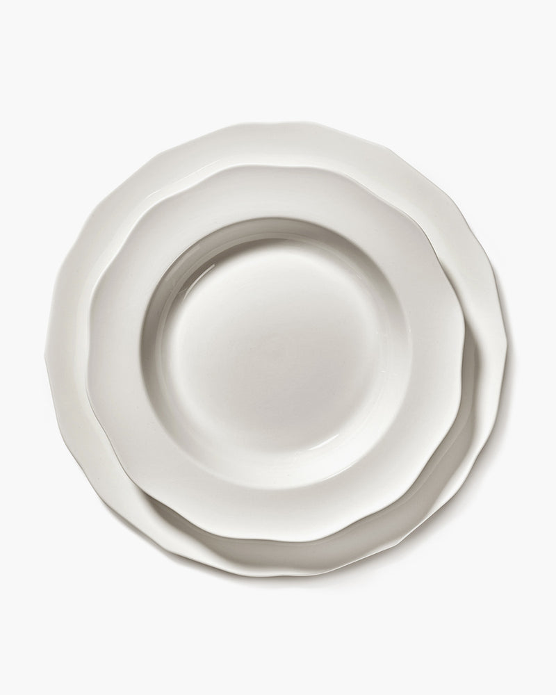 White ceramic plate with a textured rim on a white background