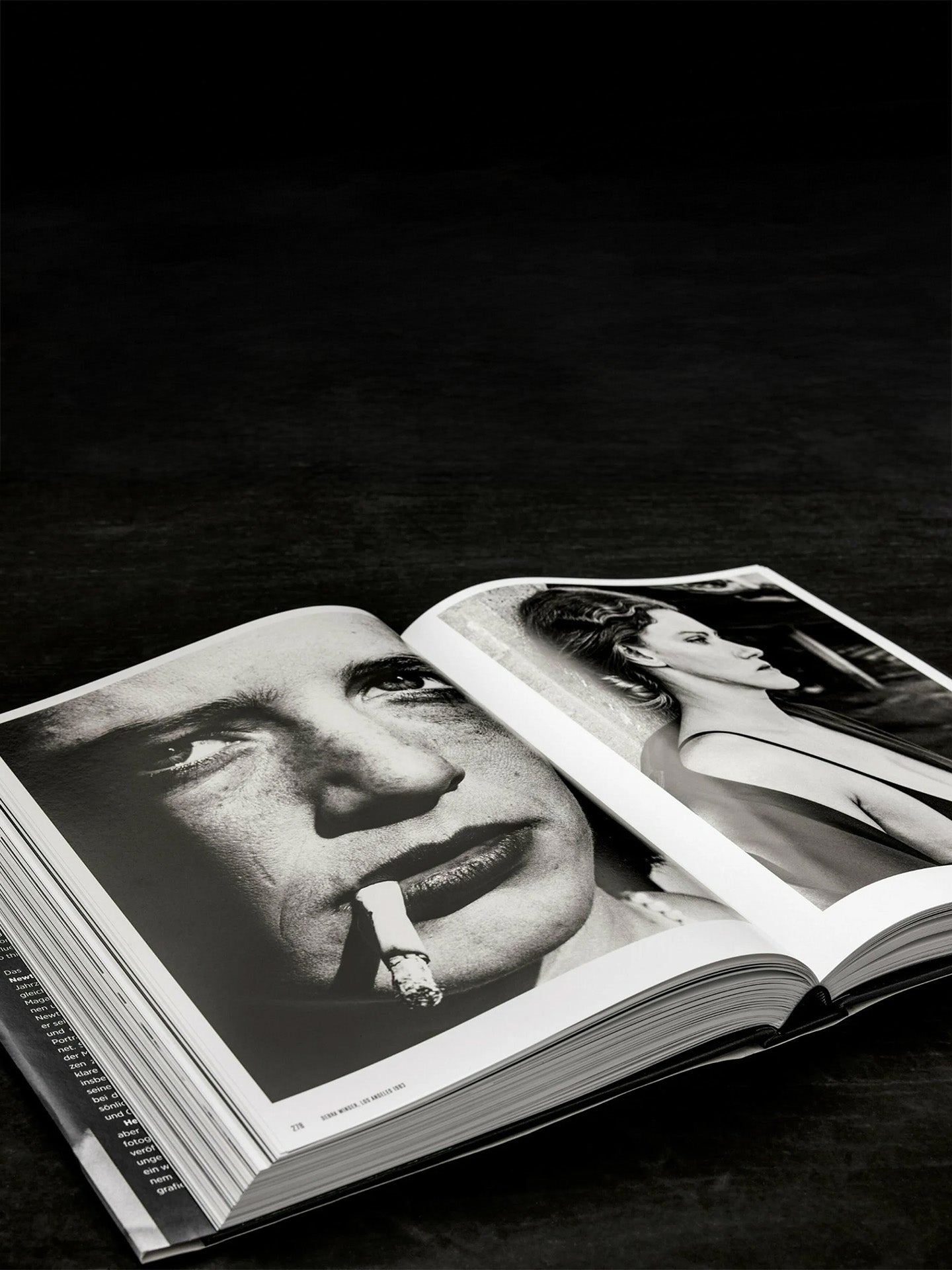 Open book displaying black and white close-up photographs of a woman and a man with a cigarette.