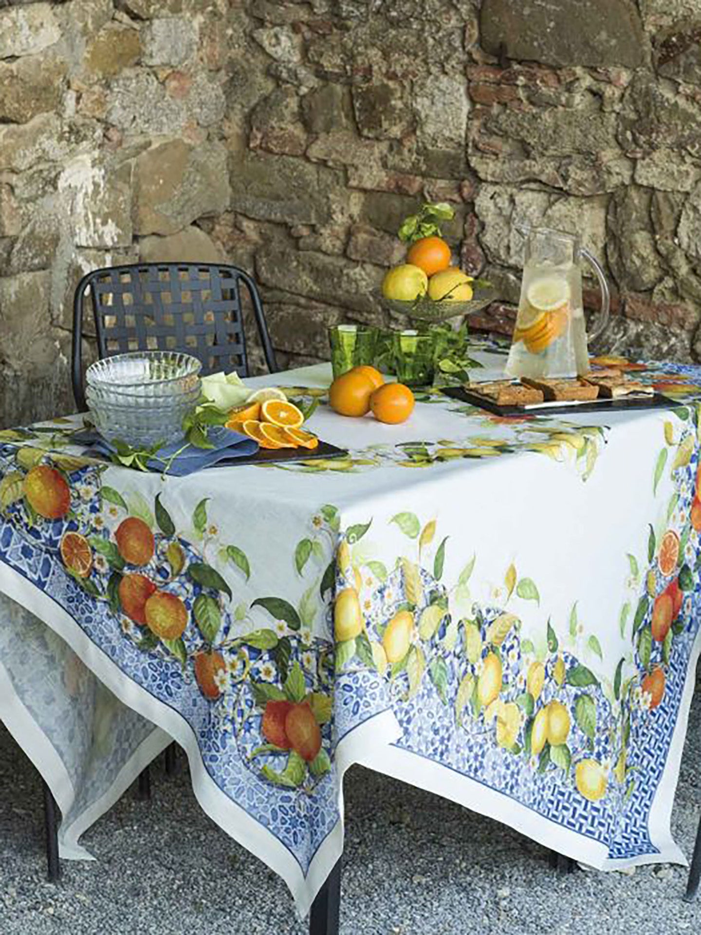 Tablecloth with fruit design on a stone-walled outdoor table
