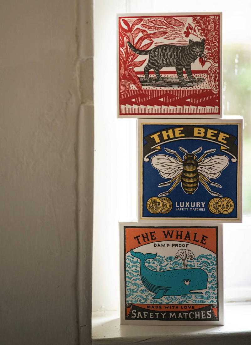 Three vintage-style matchbox covers with animal illustrations on a white surface.
