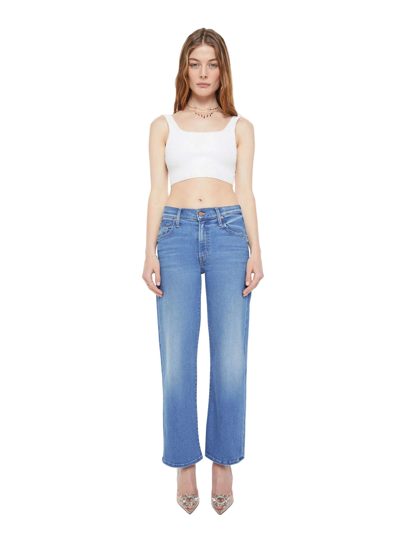 Woman wearing a white crop top and blue jeans on a white background