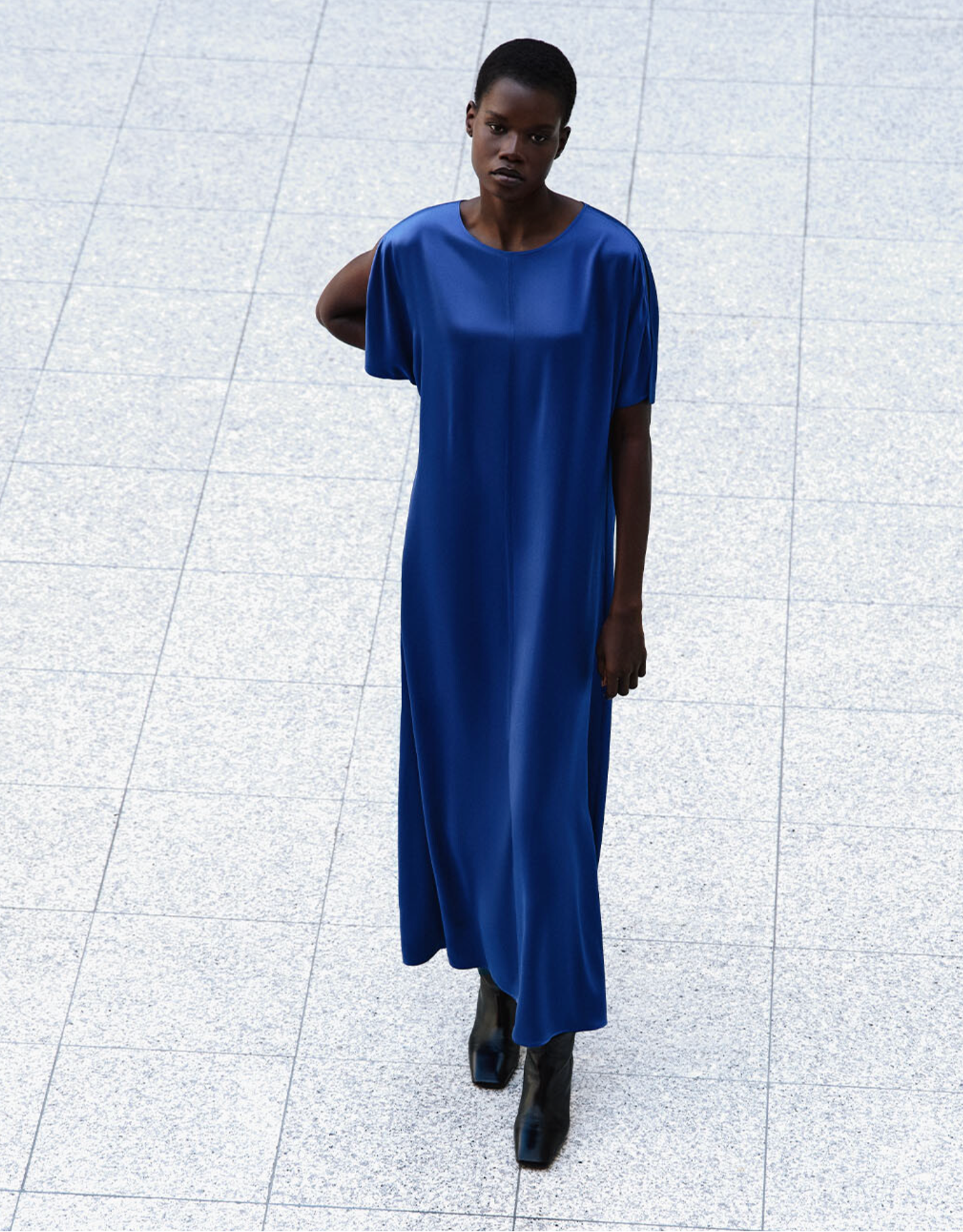 Person wearing a blue dress standing on a tiled floor