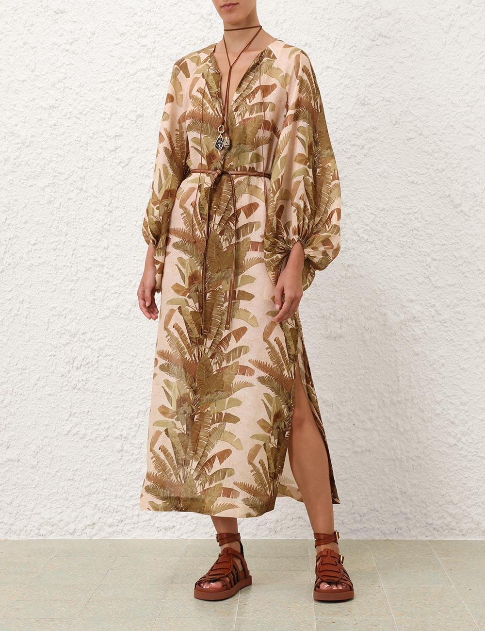 Person wearing a palm patterned linen dress with a white background