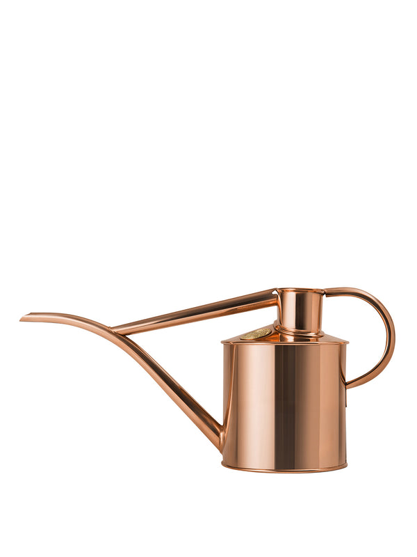 A copper-colored metal watering can with a long spout and handle, isolated on a white background.